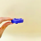 Durable press-through button fidget for desk use and sensory regulation
