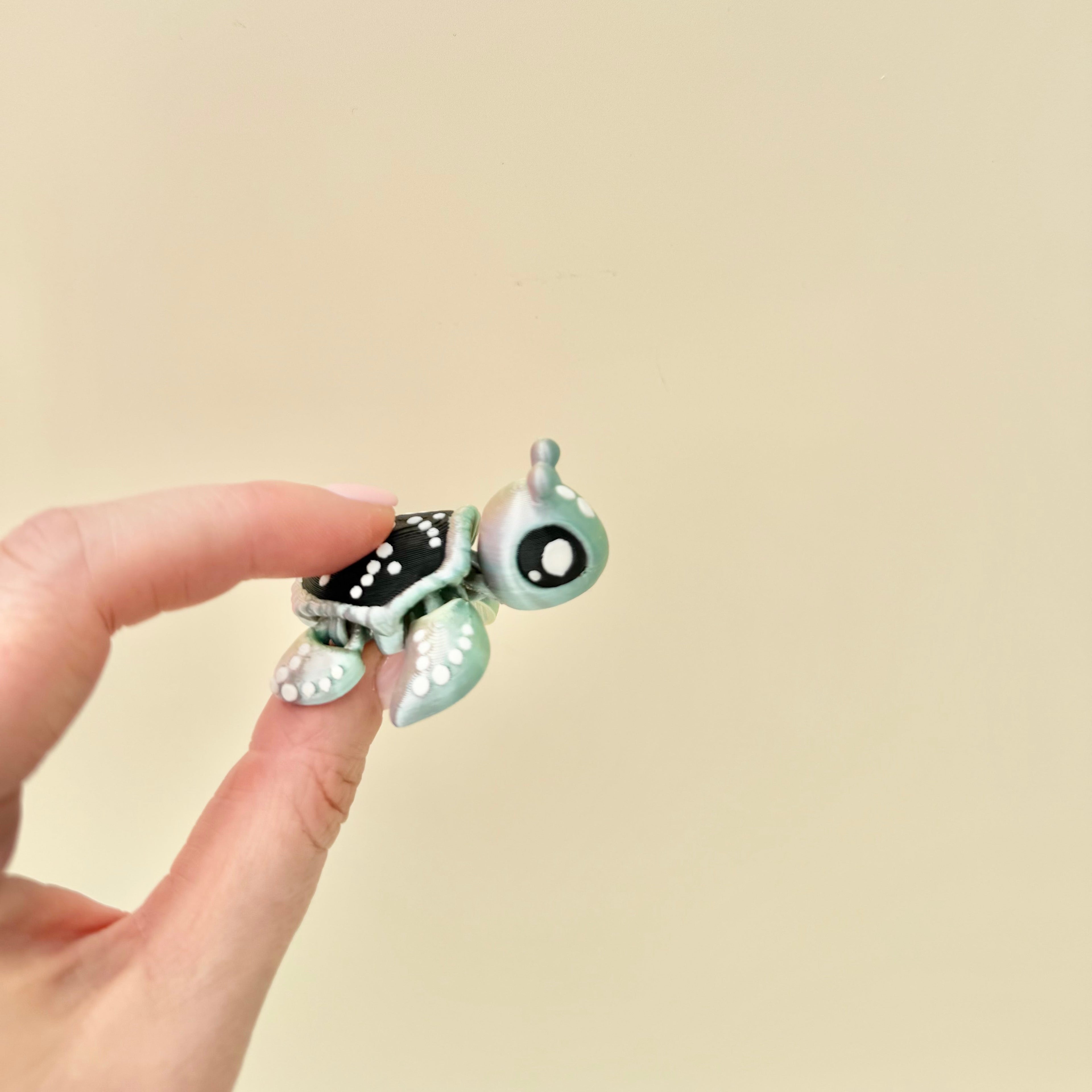 Mini articulated turtle fidget with space-themed finish designed for tactile play and everyday fidgeting