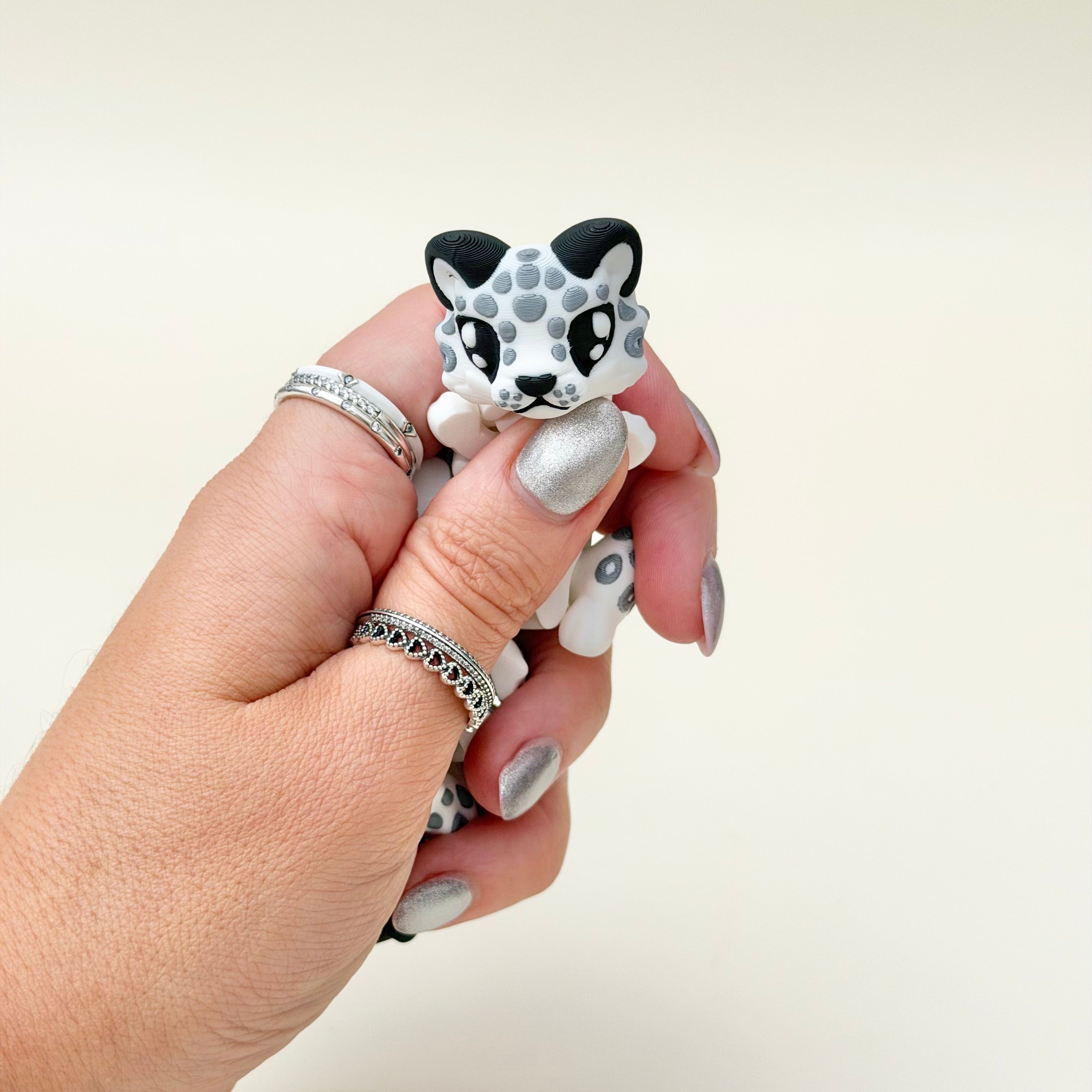 Poseable snow leopard with flexible segments and textured finish for focus breaks, grounding and stress relief.
