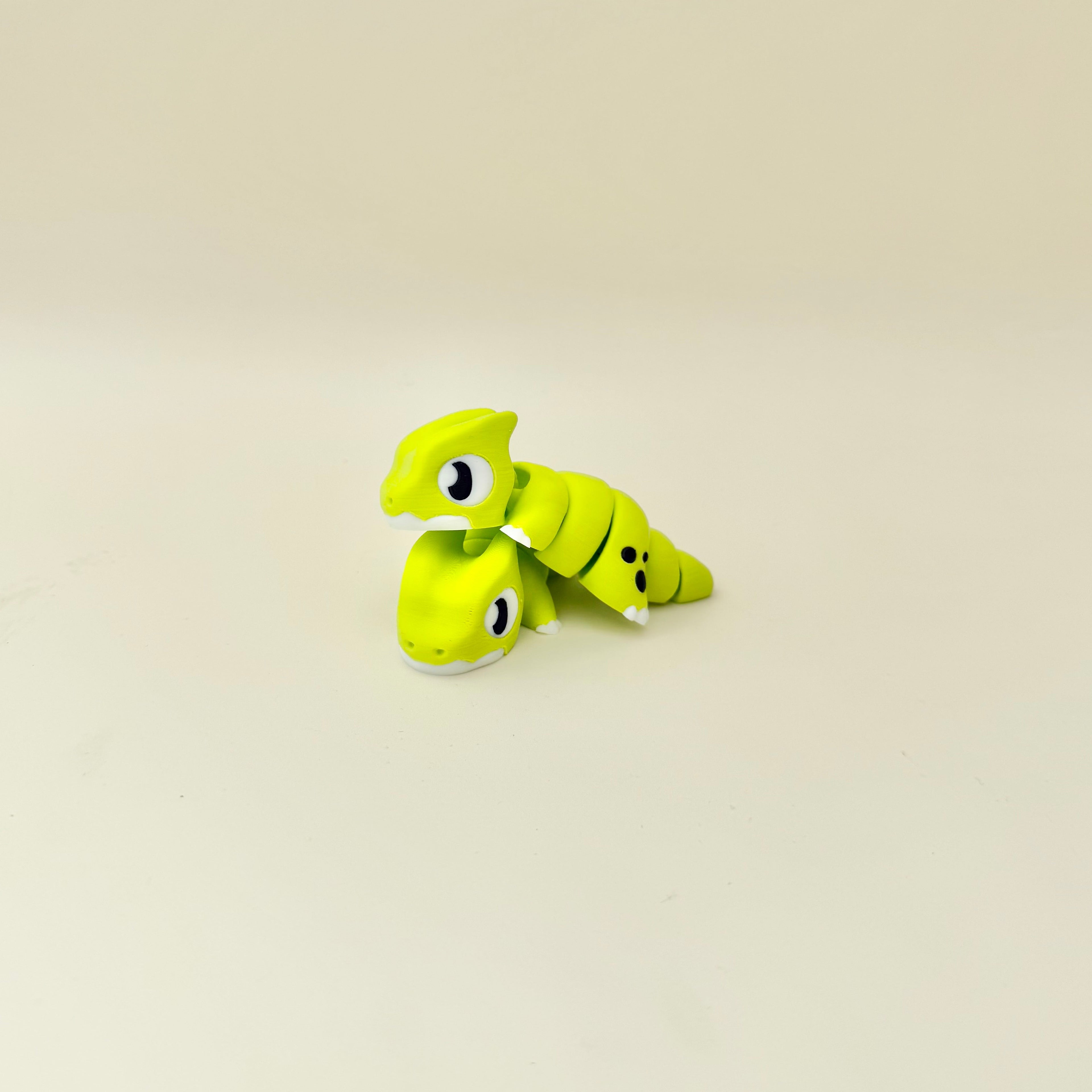 Bright green articulated dragon with repetitive movement for stimming, focus support and tactile input.