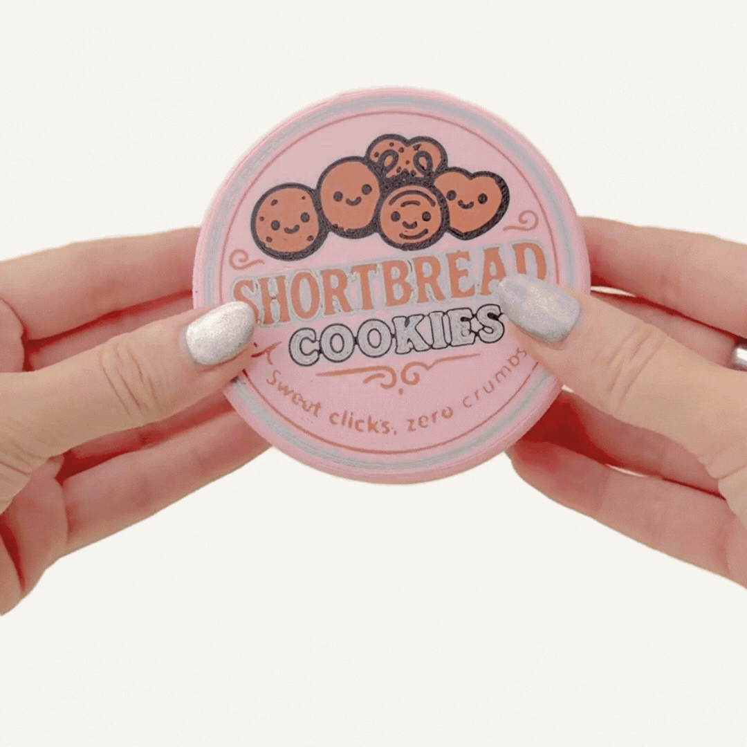 Retro tin-style clicker fidget with a working lid and textured mini sewing pieces inside for tactile play.
