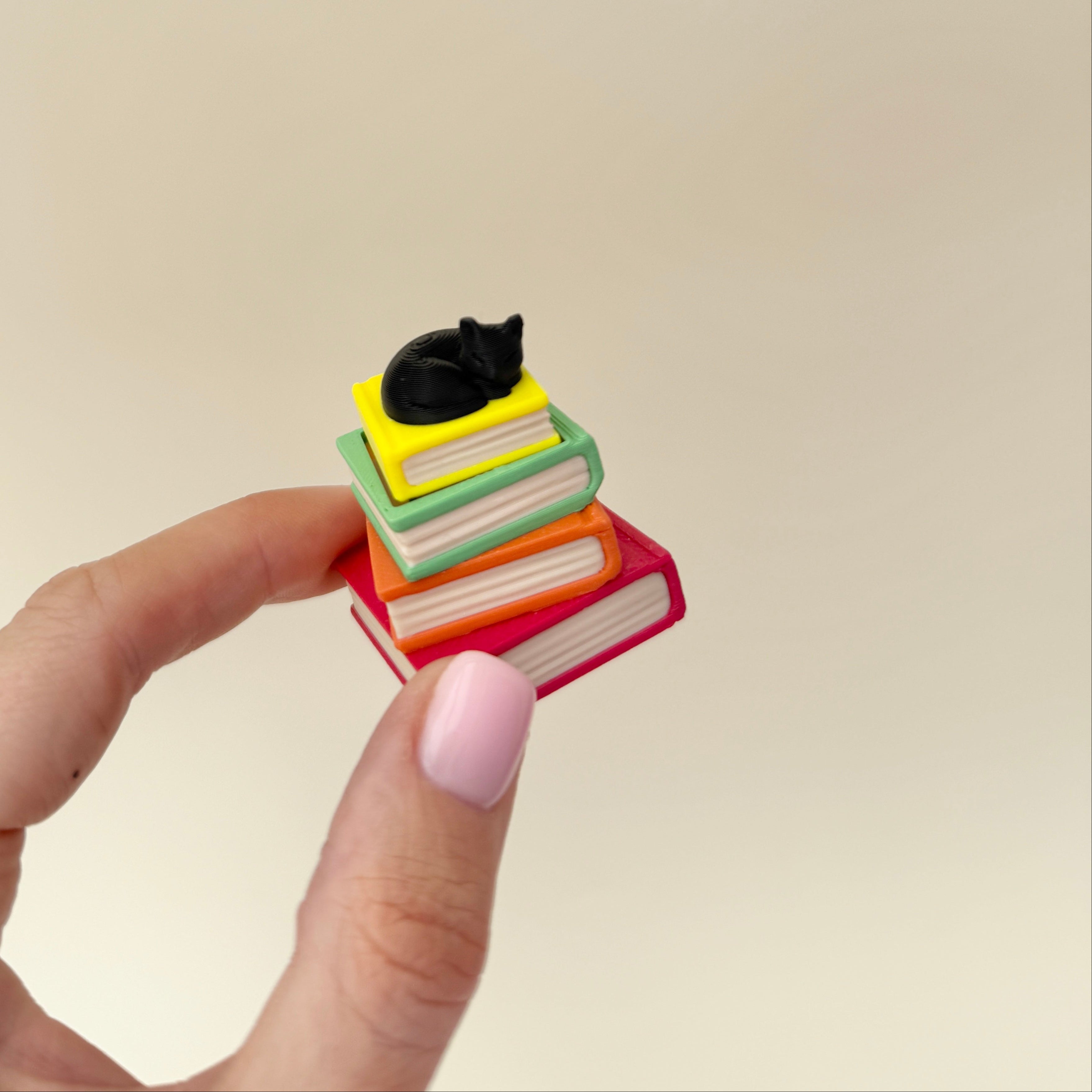 Mini stack of books with a press-to-click top and a choice of cat or dragon topper.
