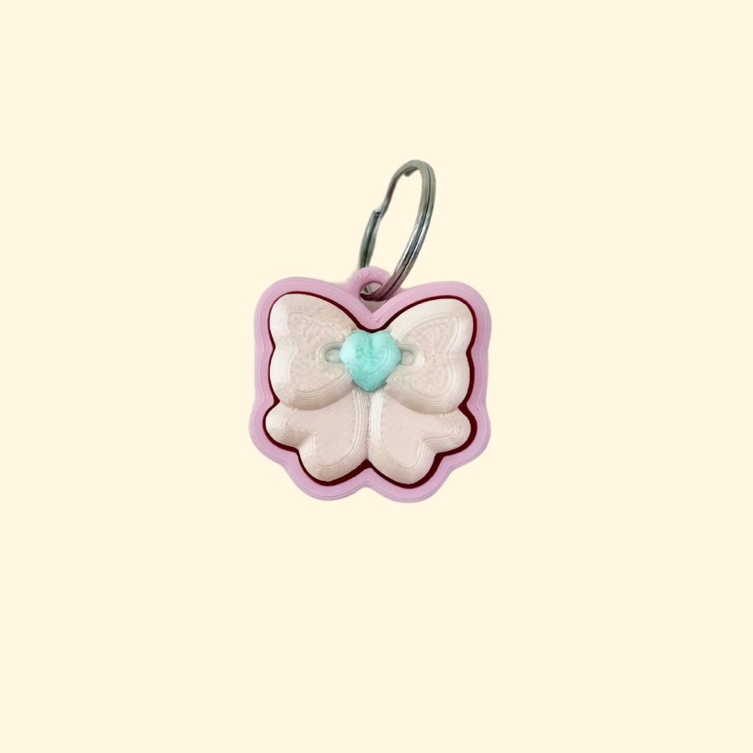 small pink bow fidget clicker on keyring, 3 cm handheld sensory toy with press-down top
