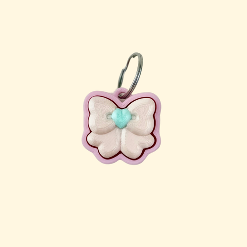 small pink bow fidget clicker on keyring, 3 cm handheld sensory toy with press-down top
