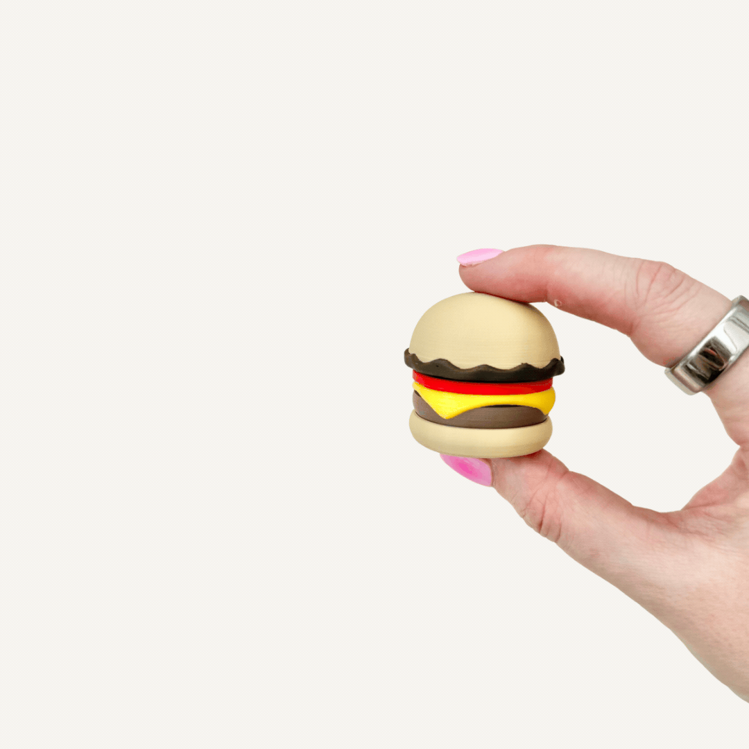 Burger sensory clicker with smooth rounded shape, pressable feedback and desk-friendly fidget use.