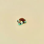 Gradient green and yellow baby turtle fidget with brown textured features.