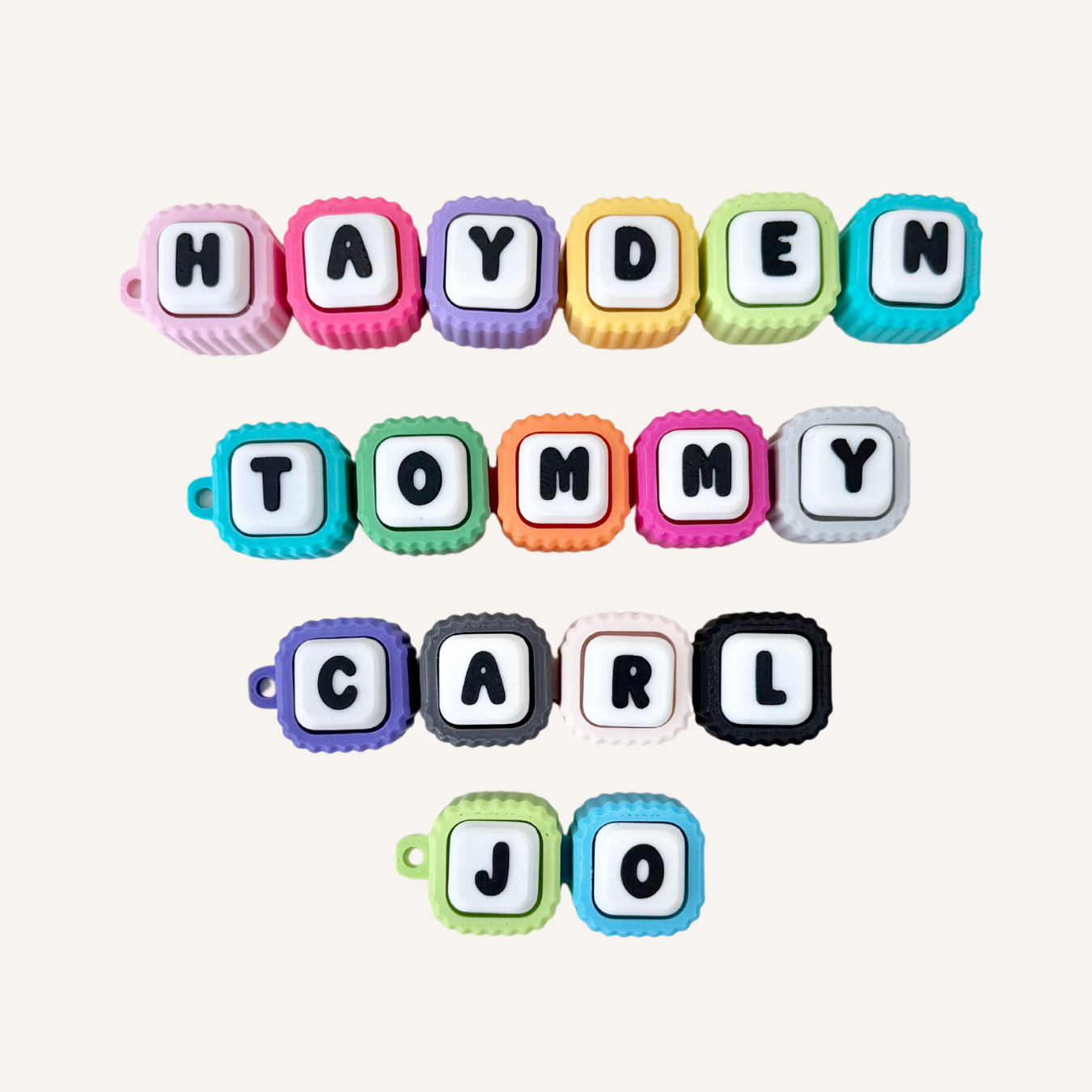 Custom linked letter clicker fidget with pressable buttons, ribbed texture and flexible movement for sensory support.