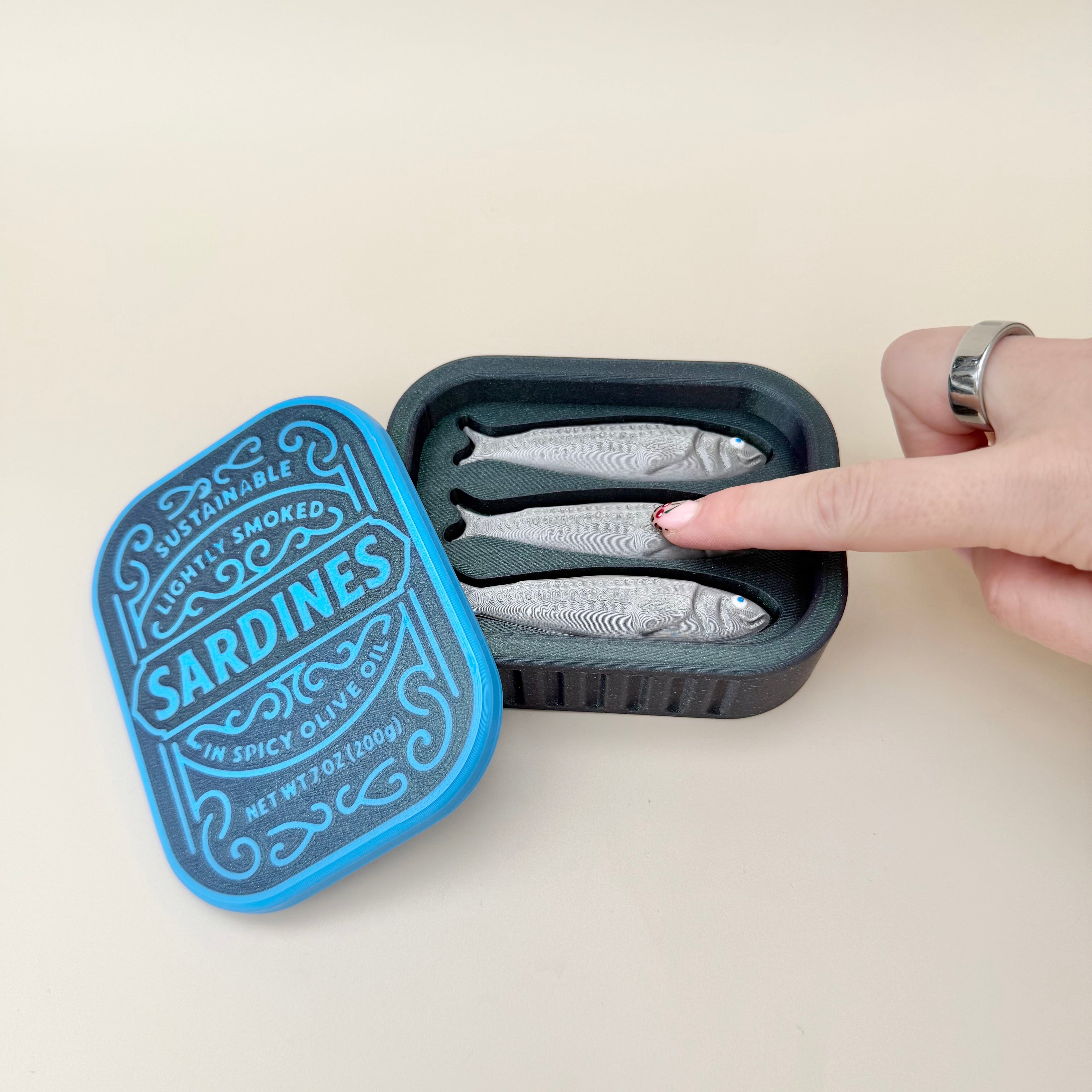 Novelty sardine tin with individual clicker pieces and smooth-open lid, great for collectors and stress relief.
