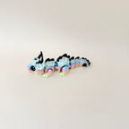 Collectable dragon fidget toy with a pastel rainbow body, white flowers, and black spiky details.