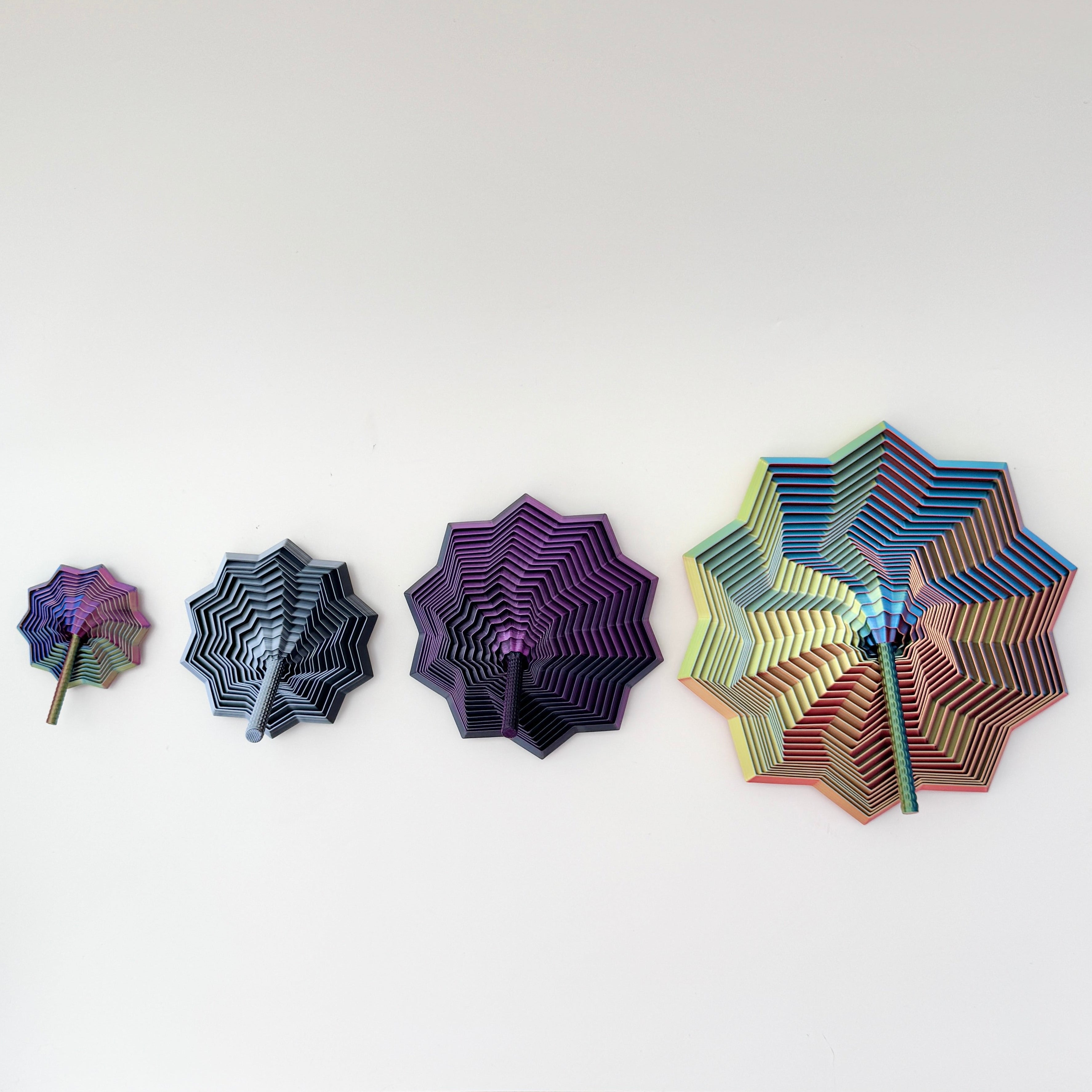Stepped petals shimmer through colours as the shape rises and collapses.
