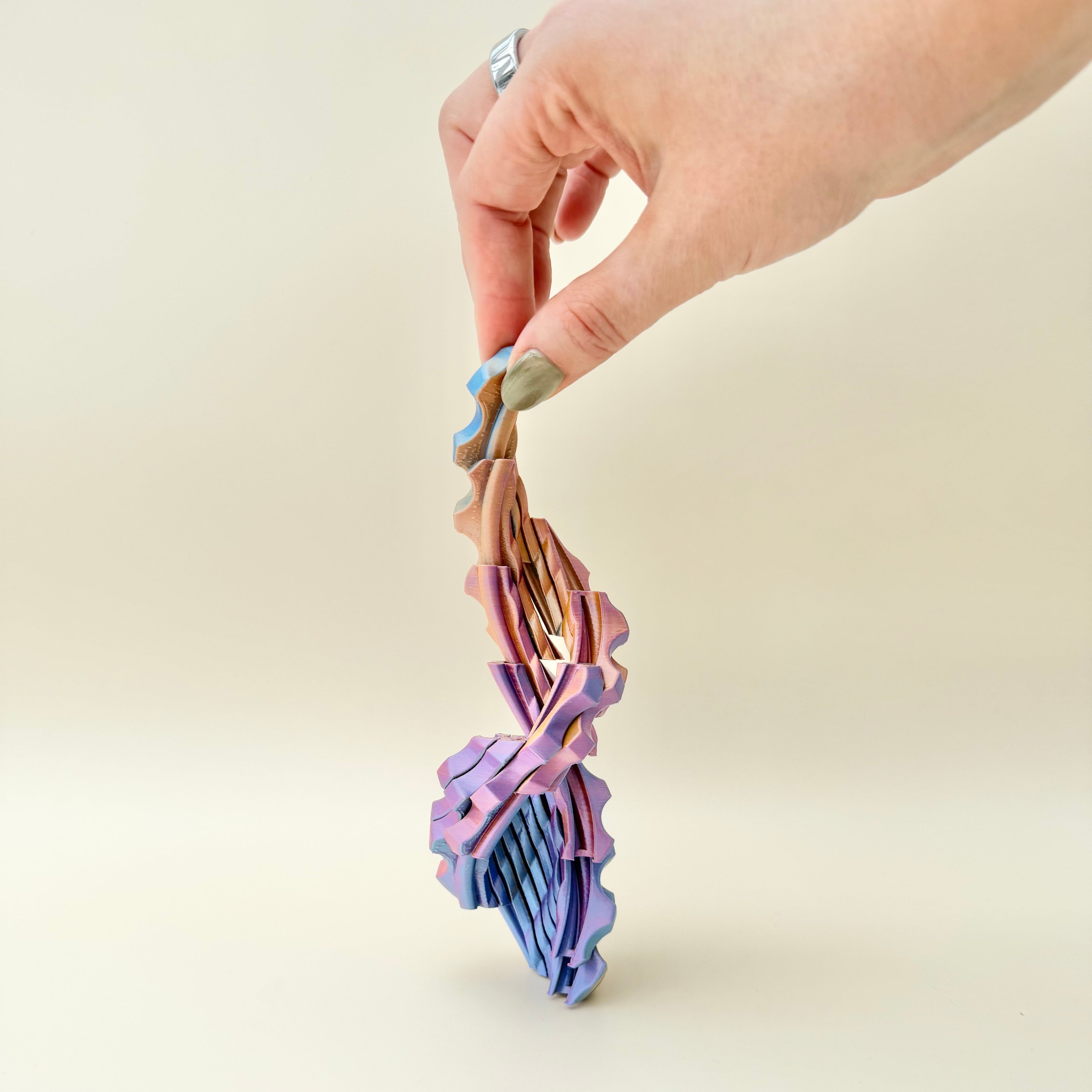 Desk toy with sliced twist design and pull-open movement for visual stimming and tactile input.
