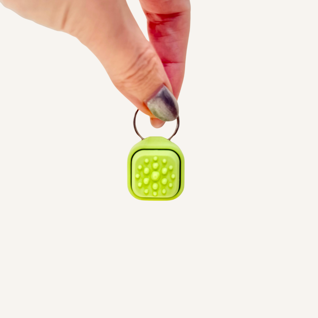 Lanyard-ready clicker with one textured tile for tracing and pressing, with Click or Quiet Click options.
