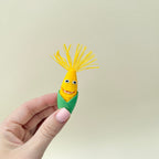 Two corn-themed fidget toys with hinged mouths and textured kernels, supplied with a small dish.
