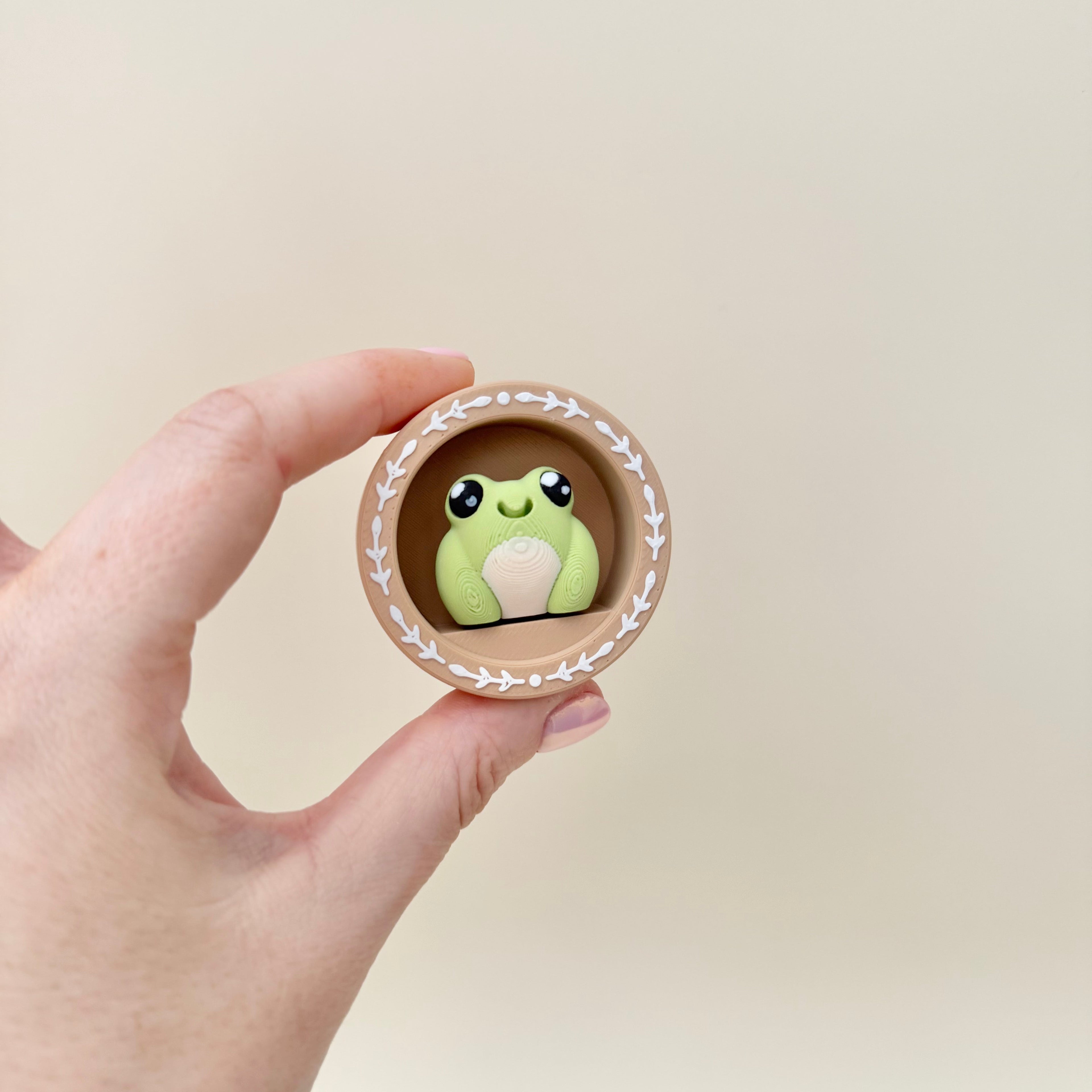 A personalised clicker fidget with a decorative frame and attachable keyring loop.
