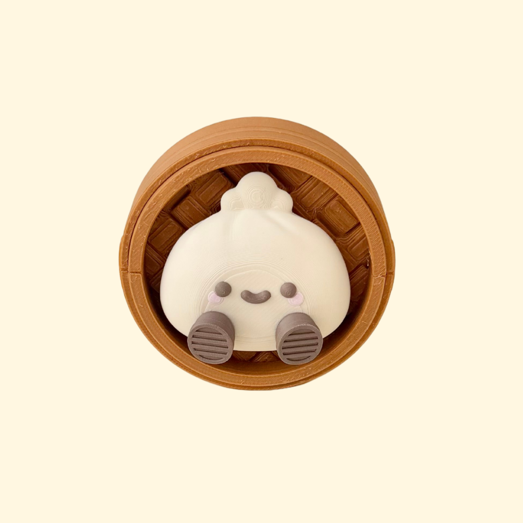Press-down clicker fidget with a smiley dumpling topper and tactile base for grounding and stimming.
