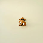 A close-up of the sausage dog fidget toy, showing its fully articulated legs, wagging tail, and adorable black-and-white spotted jumper.
