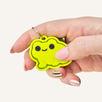 Bright green frog-shaped clicker with keyring loop for portable sensory fidgeting on keys or lanyards.

