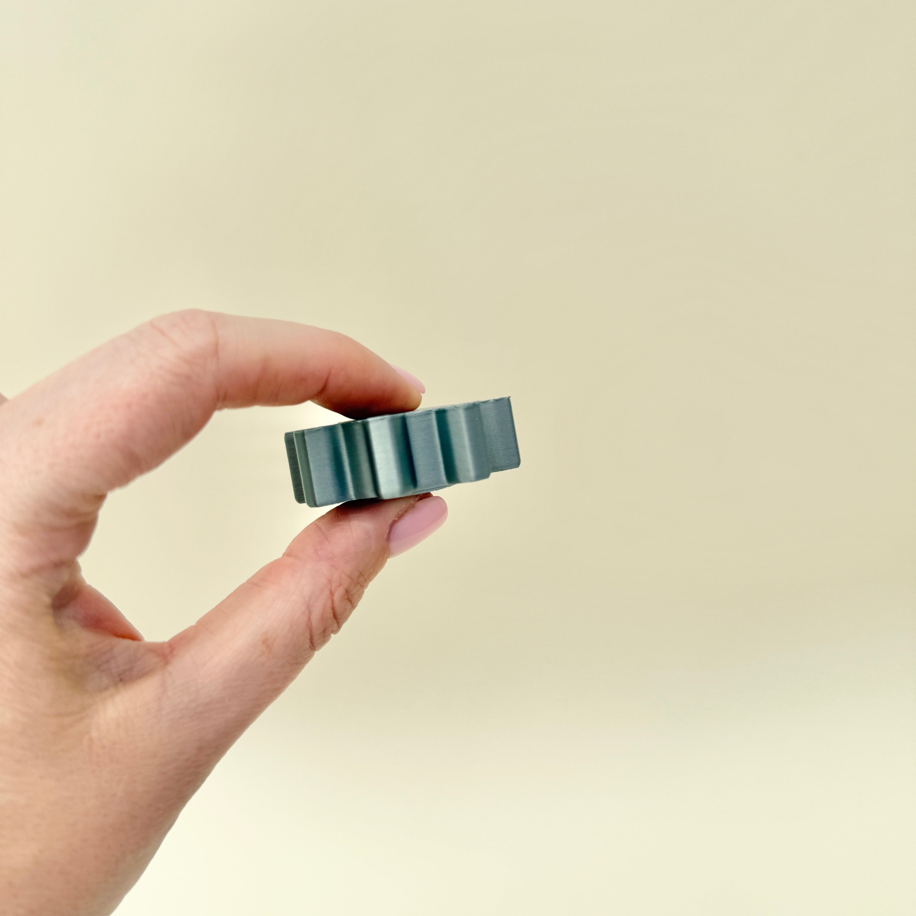 Gear-edge sensory spinner for stimming and grounding; firm ridges for thumb tracing; pocket-friendly.
