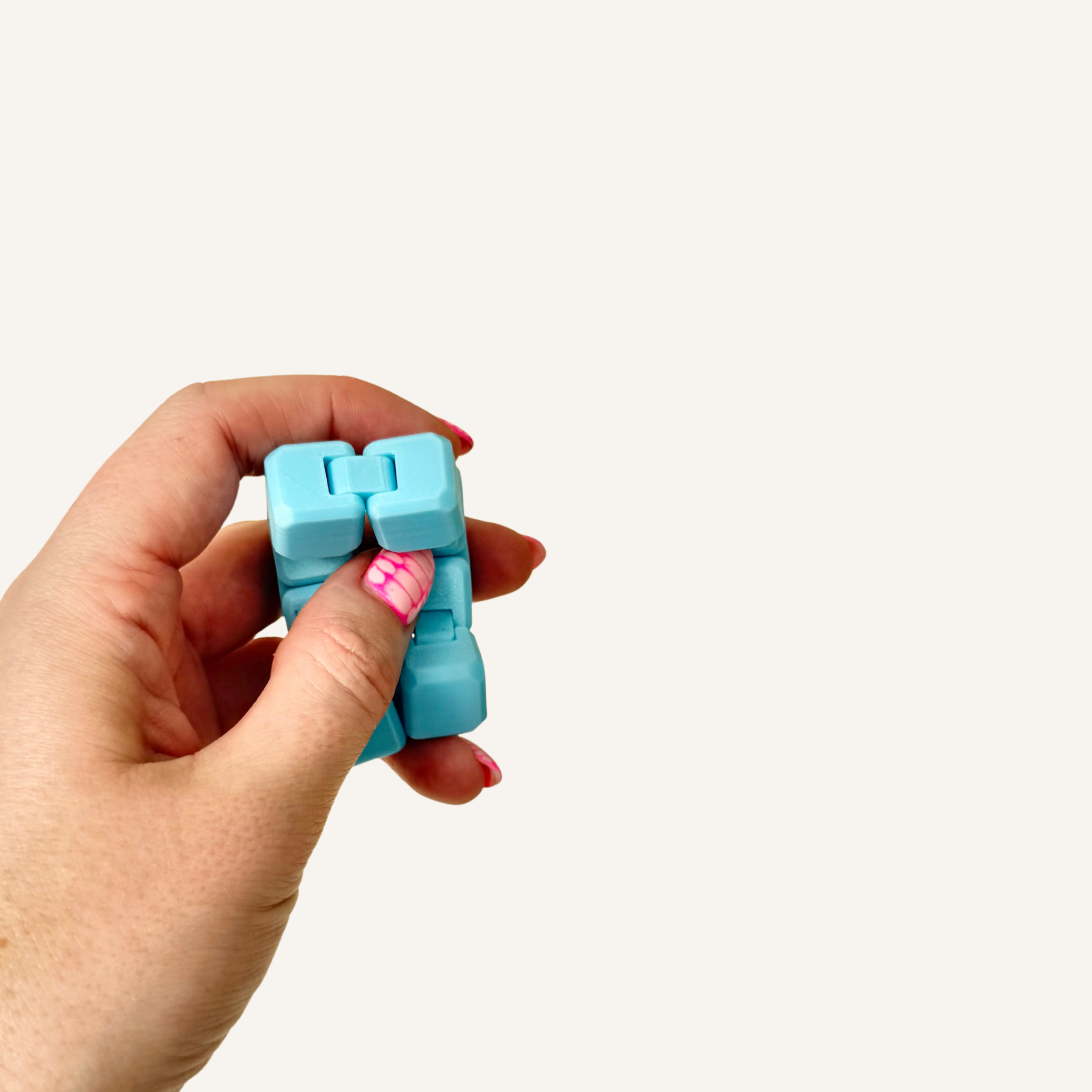 Glow in the dark mini infinity cube shown folded and unfolded to demonstrate its endless movement.