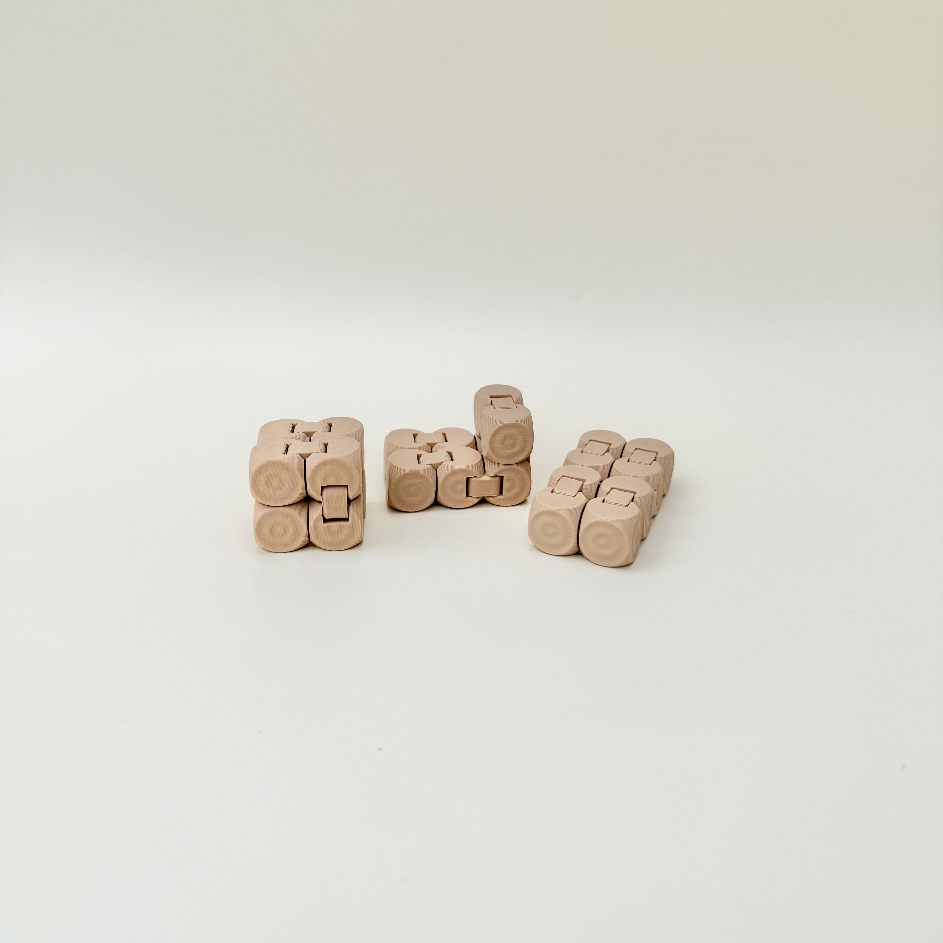Handheld sensory toy that flips and clicks between shapes with tactile dot texture for steady stims.
