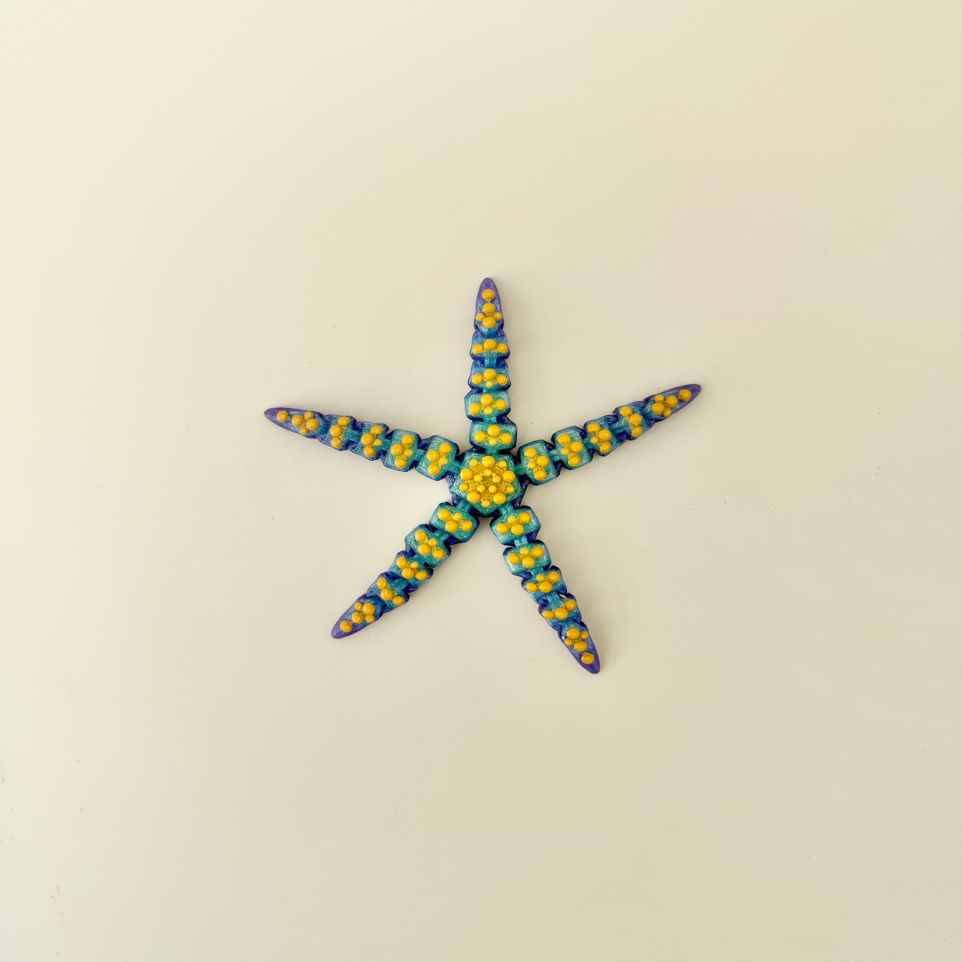 A smooth, articulated starfish designed for quiet desk fidgeting and everyday sensory use.
