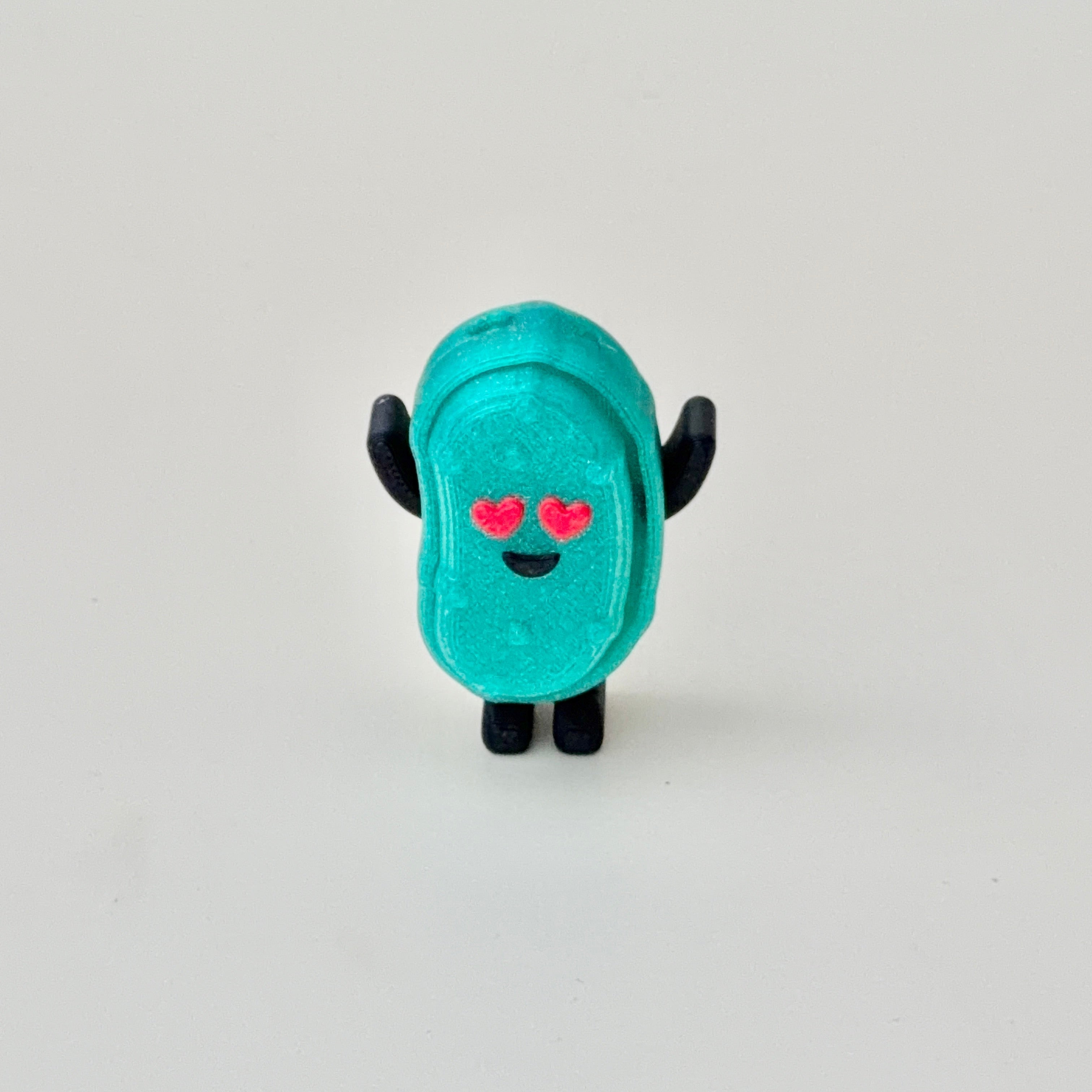 Mini sensory clicker fidget with a shimmery finish and textured feel, designed for portable calming input.
