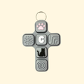 Cross-shaped fidget toy with various textured and shaped buttons on a beige background
