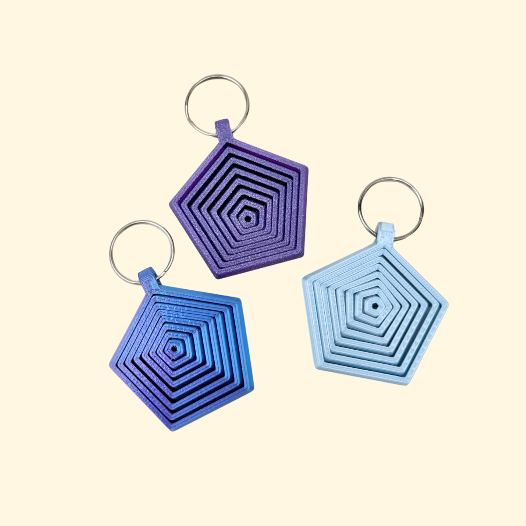Layered hexagon fidget add-on with smooth sliding movement and visual stimming, designed for lanyards and keyrings.
