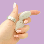 Two light grey cratered moons connected by a hinge for repetitive sensory movement.