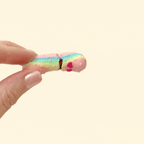 A shiny, colour-changing rainbow pickle fidget toy with heart eyes, showing its interactive opening mouth.