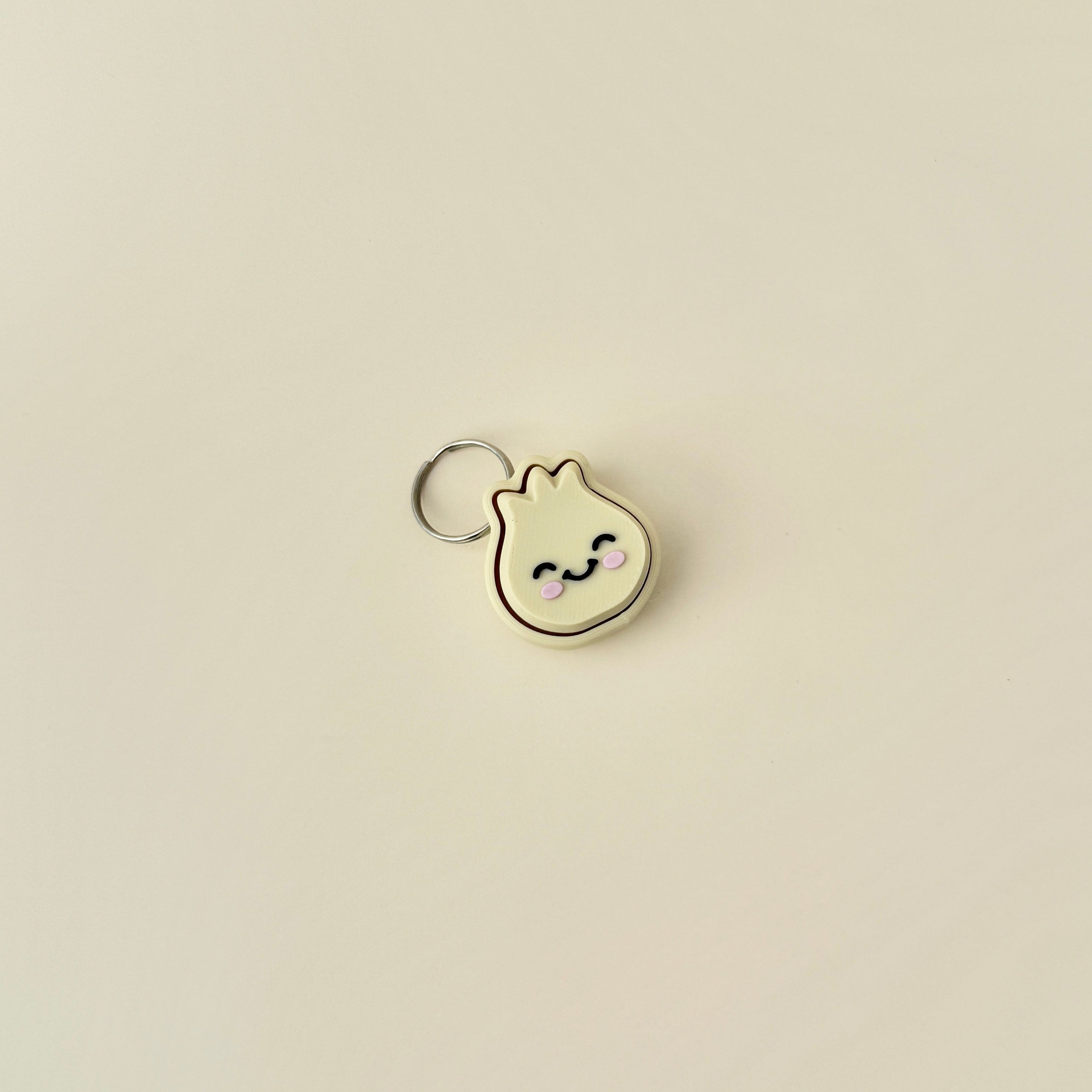 A cute, small dumpling clicker with a keychain, featuring a soft press mechanism that makes an audible clicking noise.