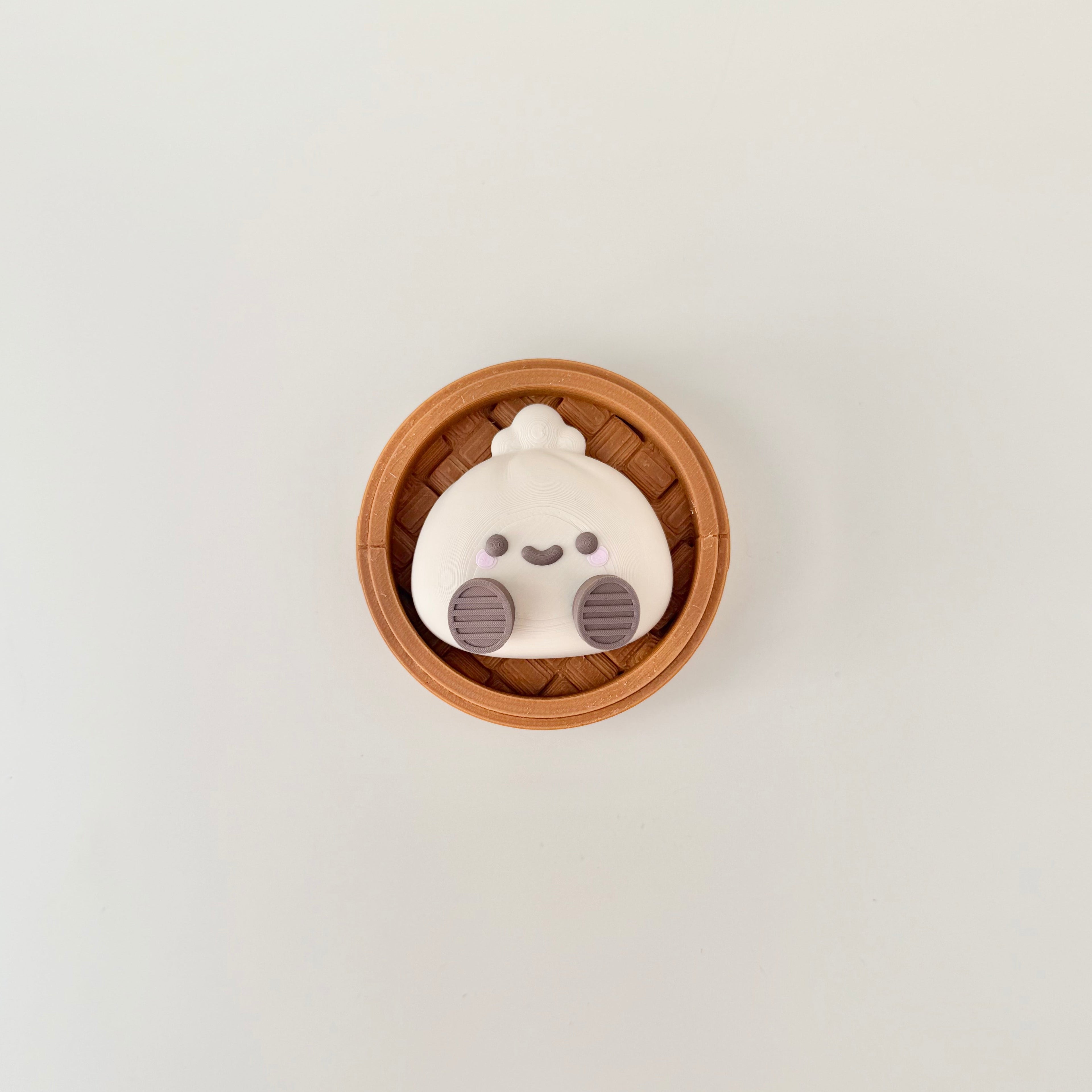 Novelty dumpling clicker fidget that looks like desk decor but works as a satisfying sensory tool.
