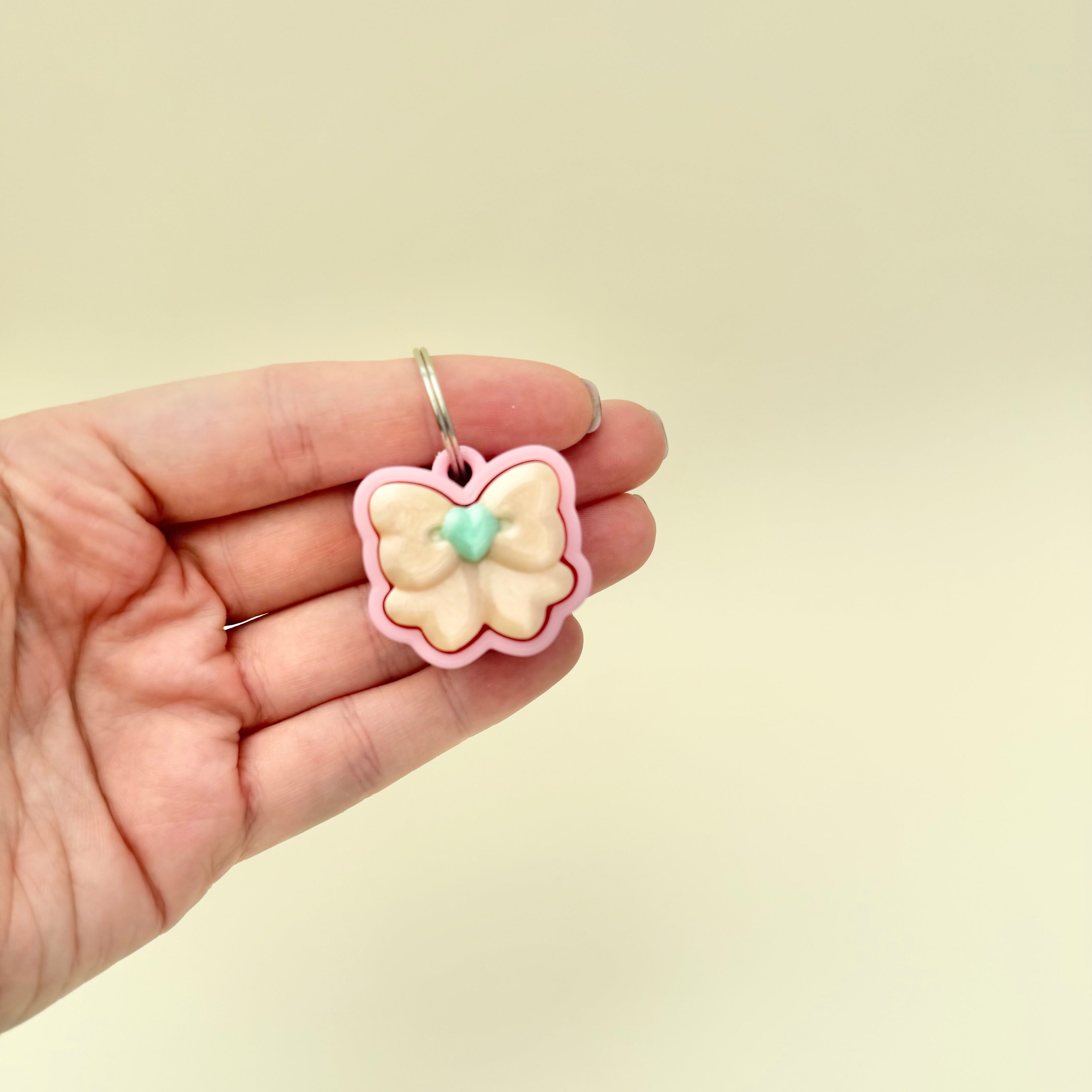 lightweight pink bow click toy for on-the-go fidgeting, available in quiet or standard click
