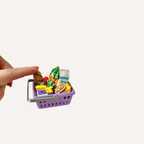 Shopping basket sensory fidget filled with miniature food items and realistic textures.