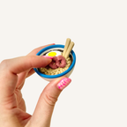 Miniature ramen bowl fidget with realistic food details and mechanical click action.
