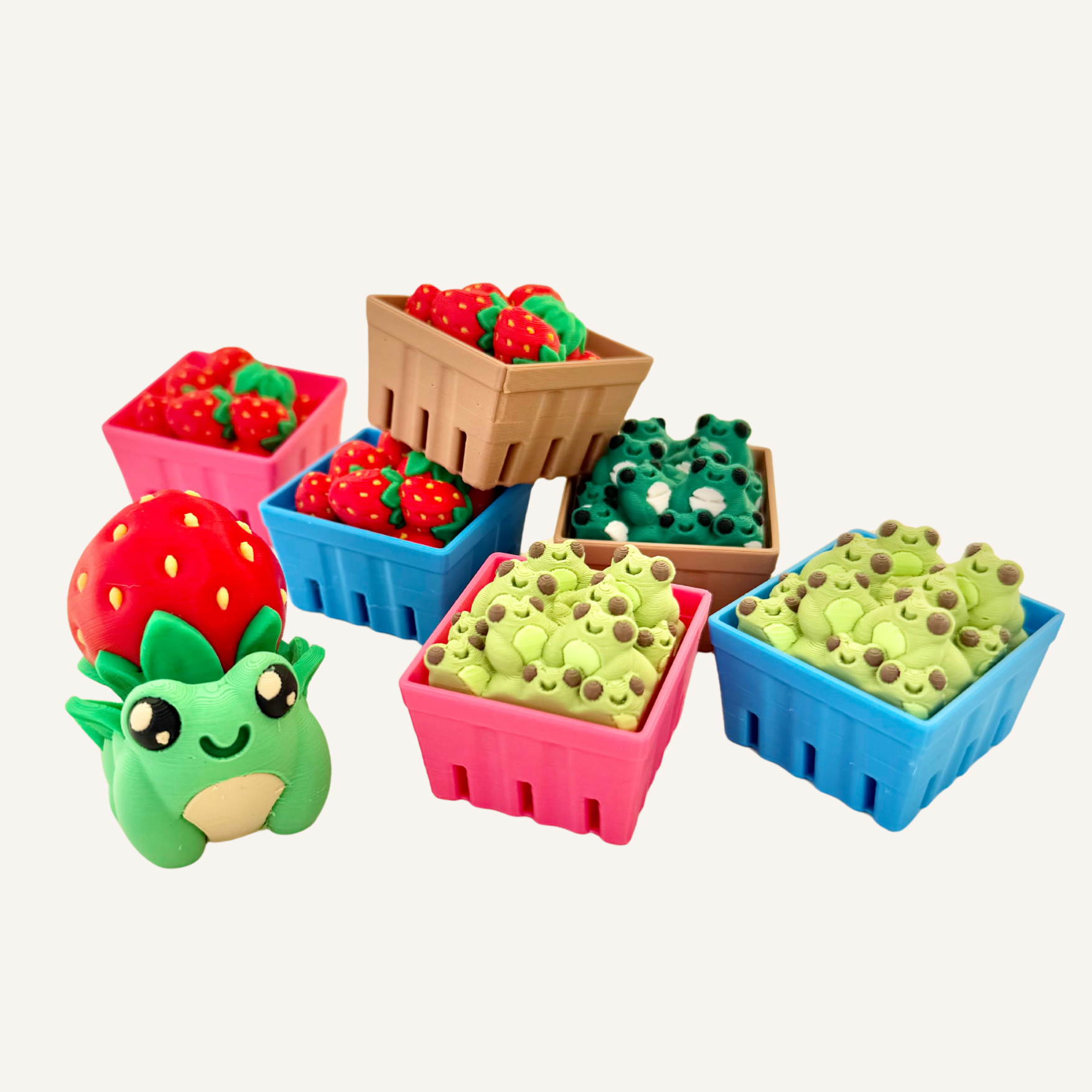 Small sensory fidget toys featuring frogs and strawberries designed for tactile play and repetitive use