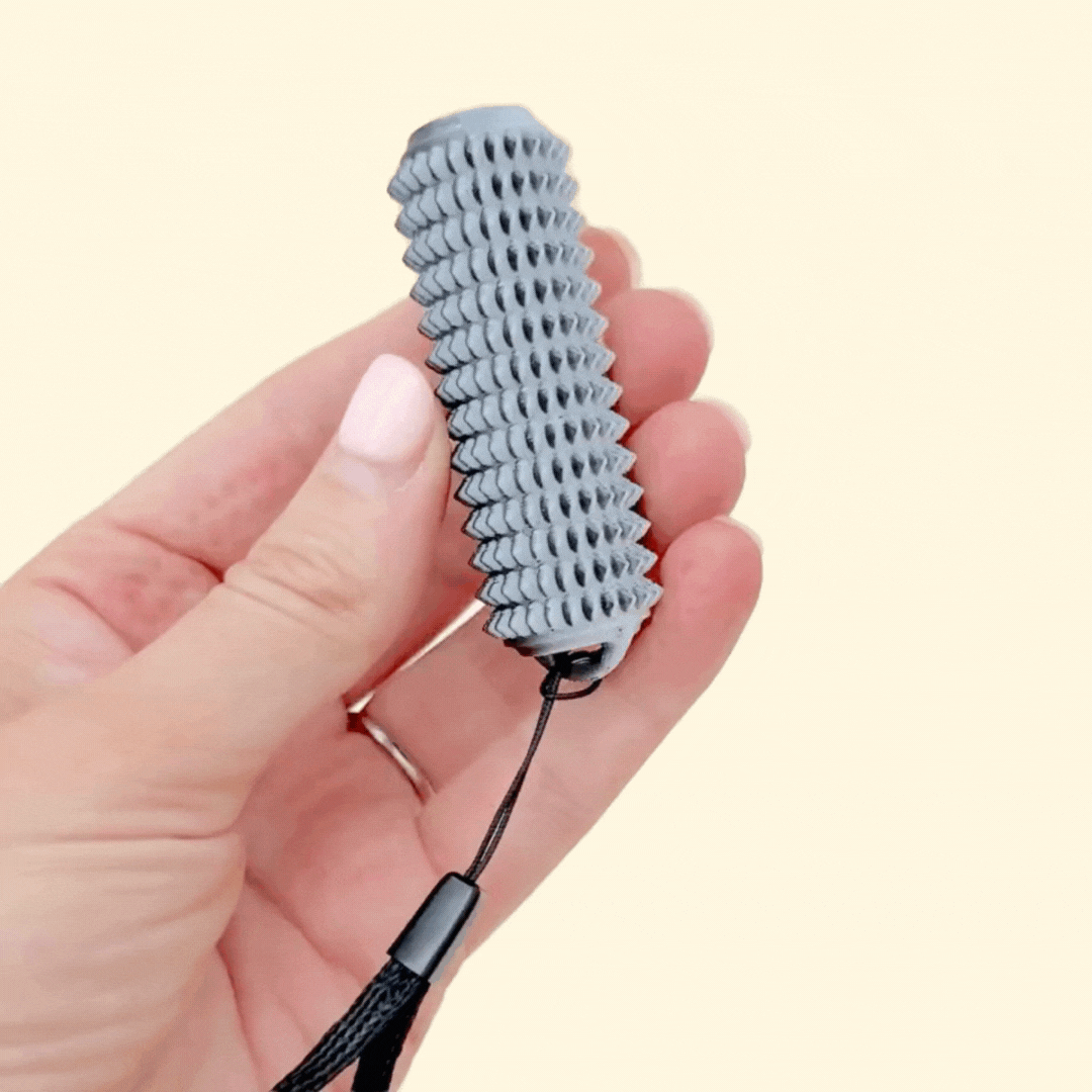 rigid handheld stim tool with mid-intensity spikes, colour-shifting black and white finish, and a wrist strap
