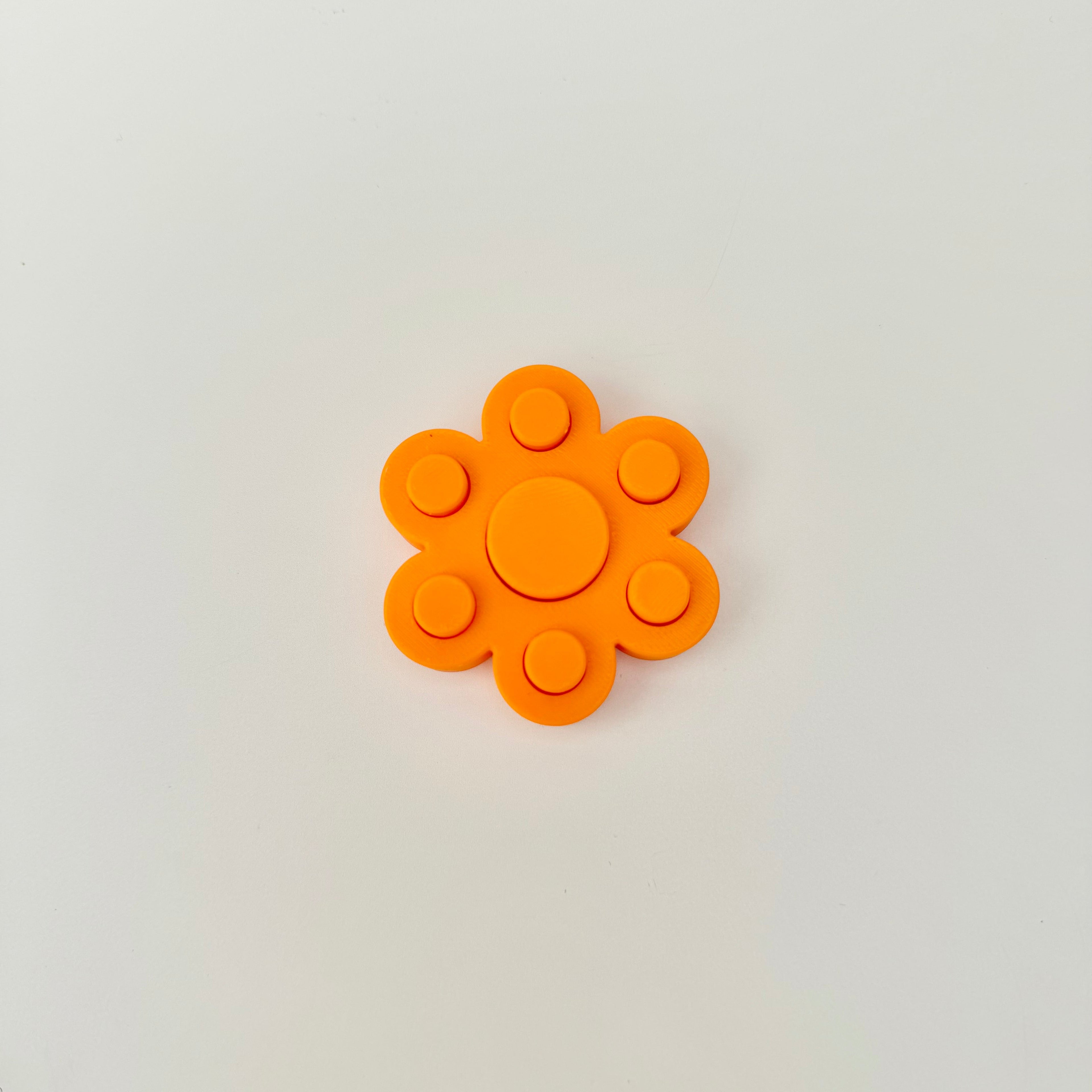 Handheld PopBack fidget spinner designed for smooth spinning and satisfying press feedback in a small size.
