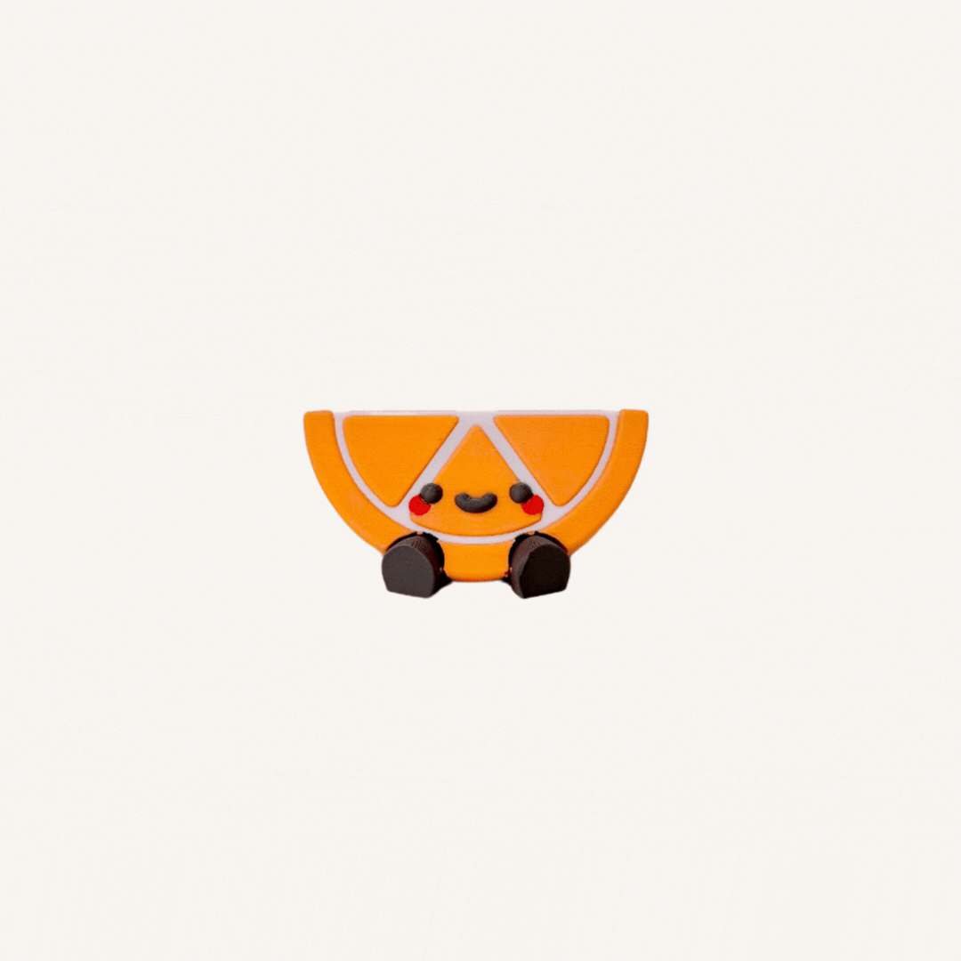 Cute mini orange slice character with dangling legs designed for desks, shelves and calming decor spaces
