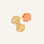 Seashell-shaped flip fidget in soft pastel colours for repetitive sensory movement.