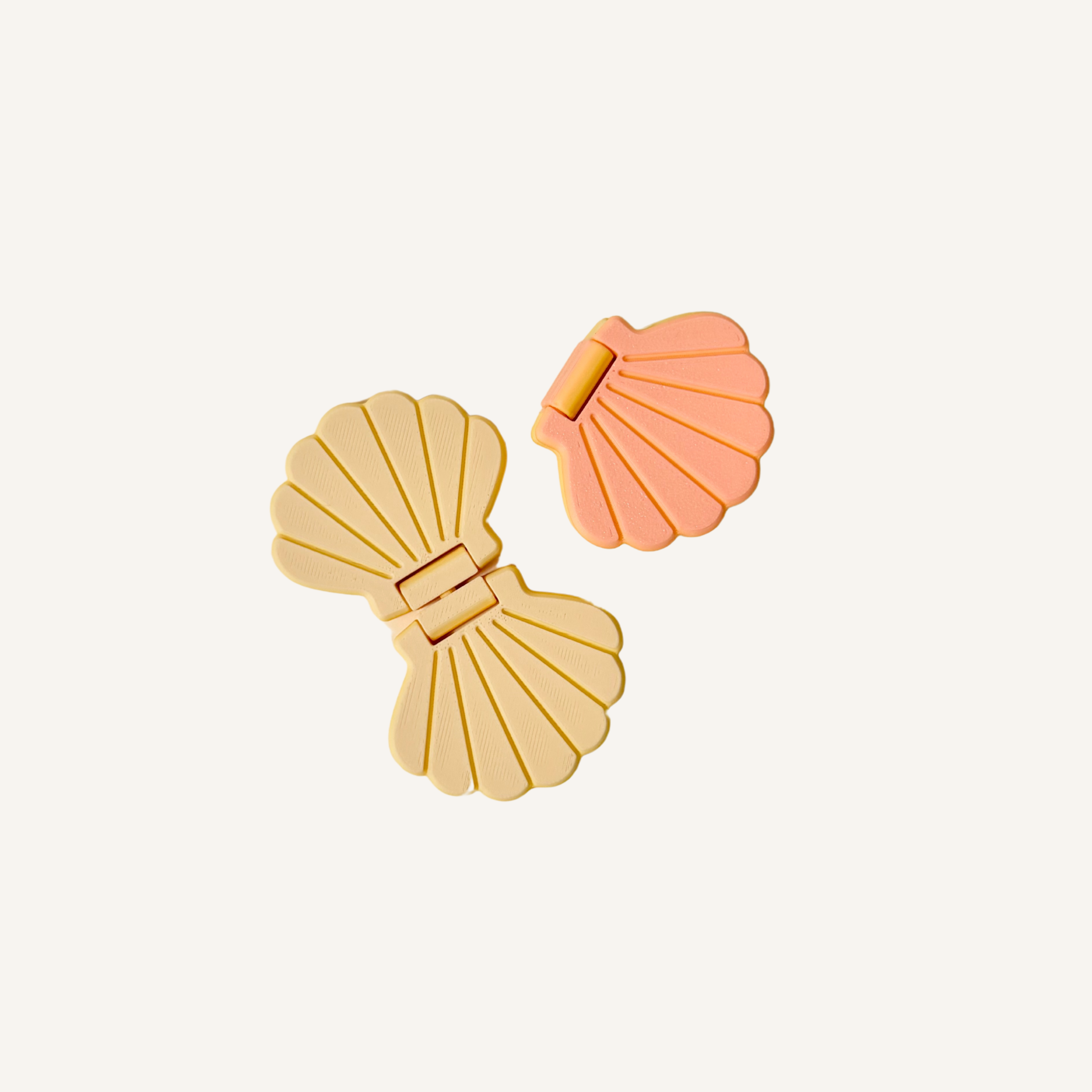 Seashell-shaped flip fidget in soft pastel colours for repetitive sensory movement.