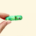 Sparkly green pickle fidget toy with a cyclops eye, perfect for pickle lovers.