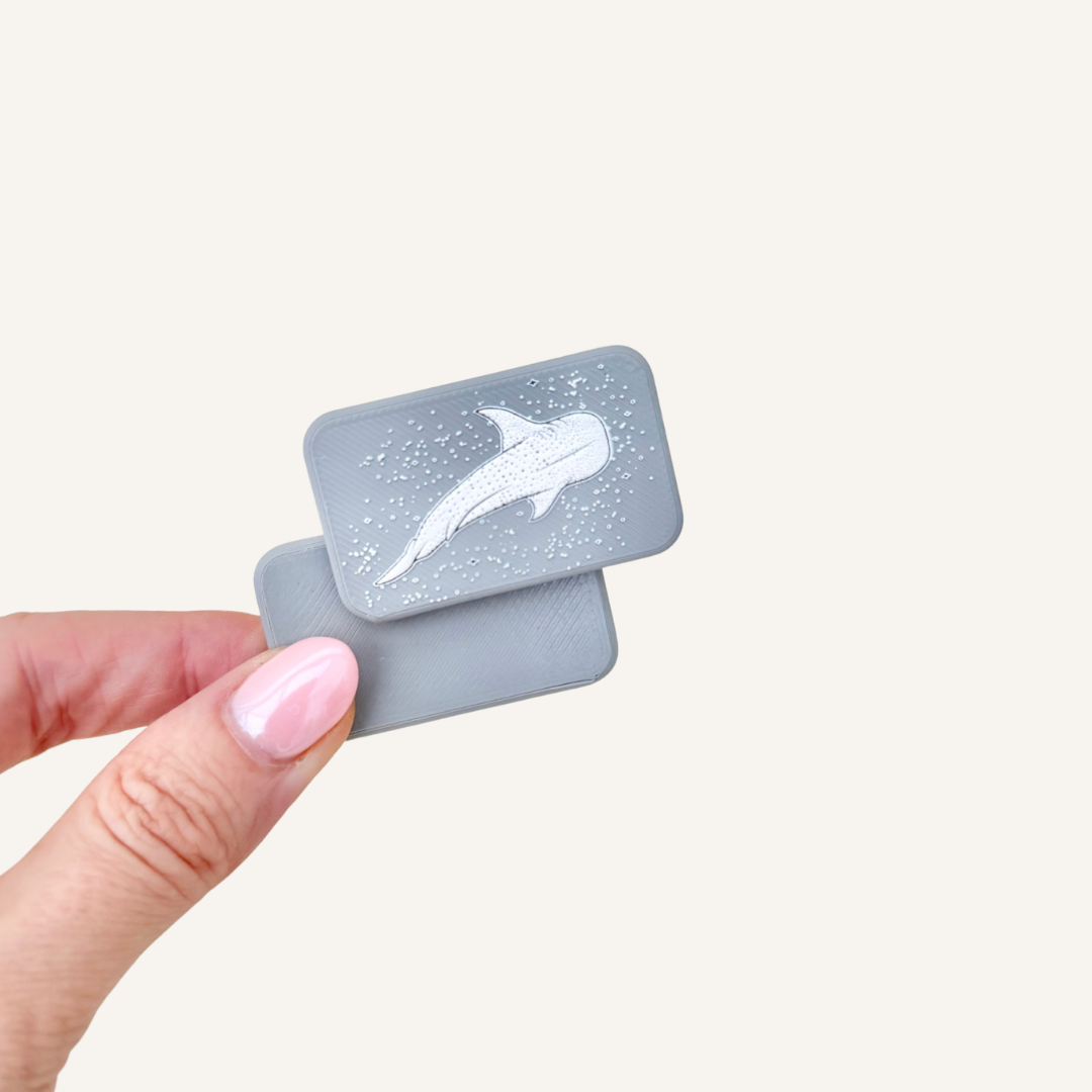 Compact magnetic sensory fidget pair with tactile whale shark artwork.