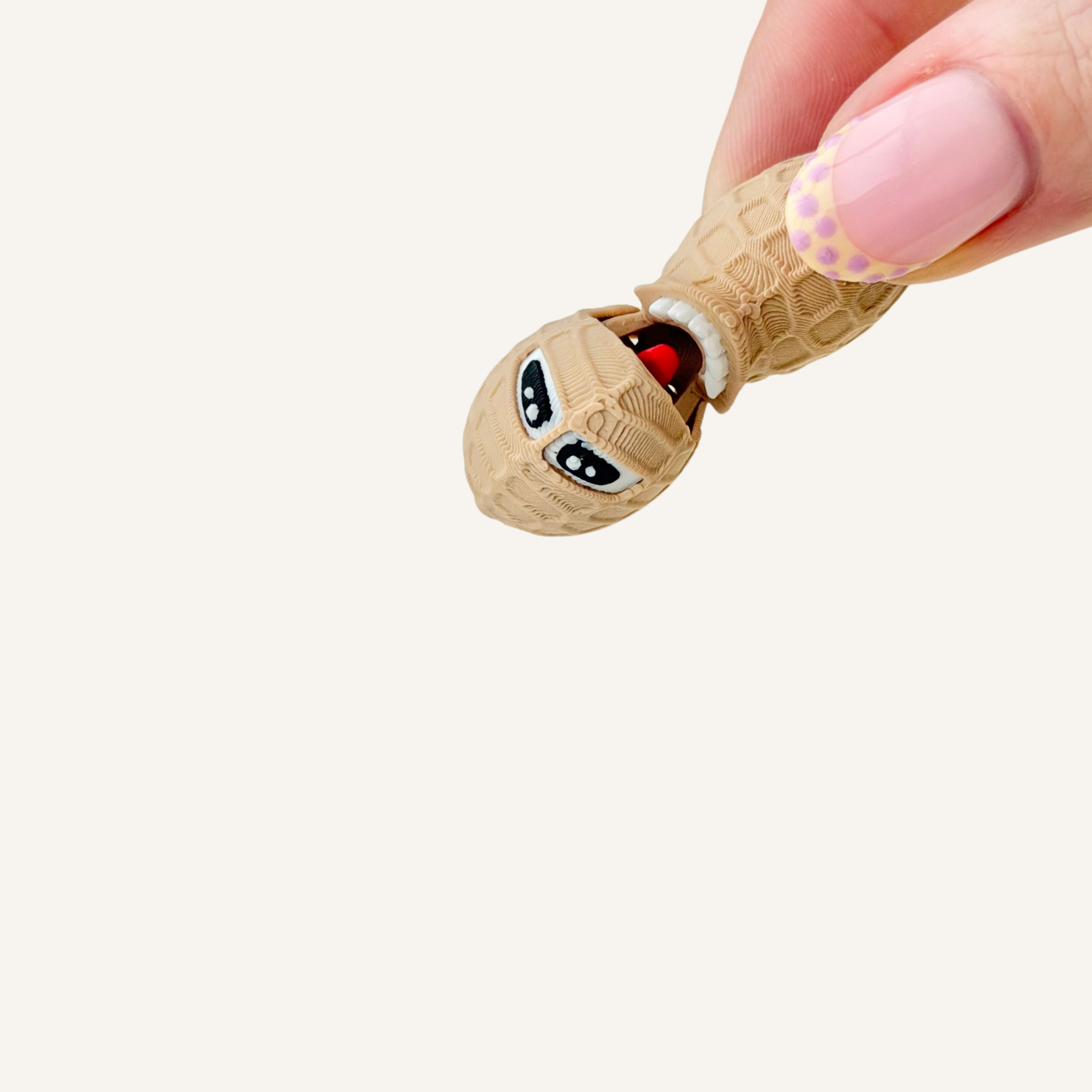 Small articulated peanut fidget with hinged motion designed for light tactile interaction and discreet hand movement.
