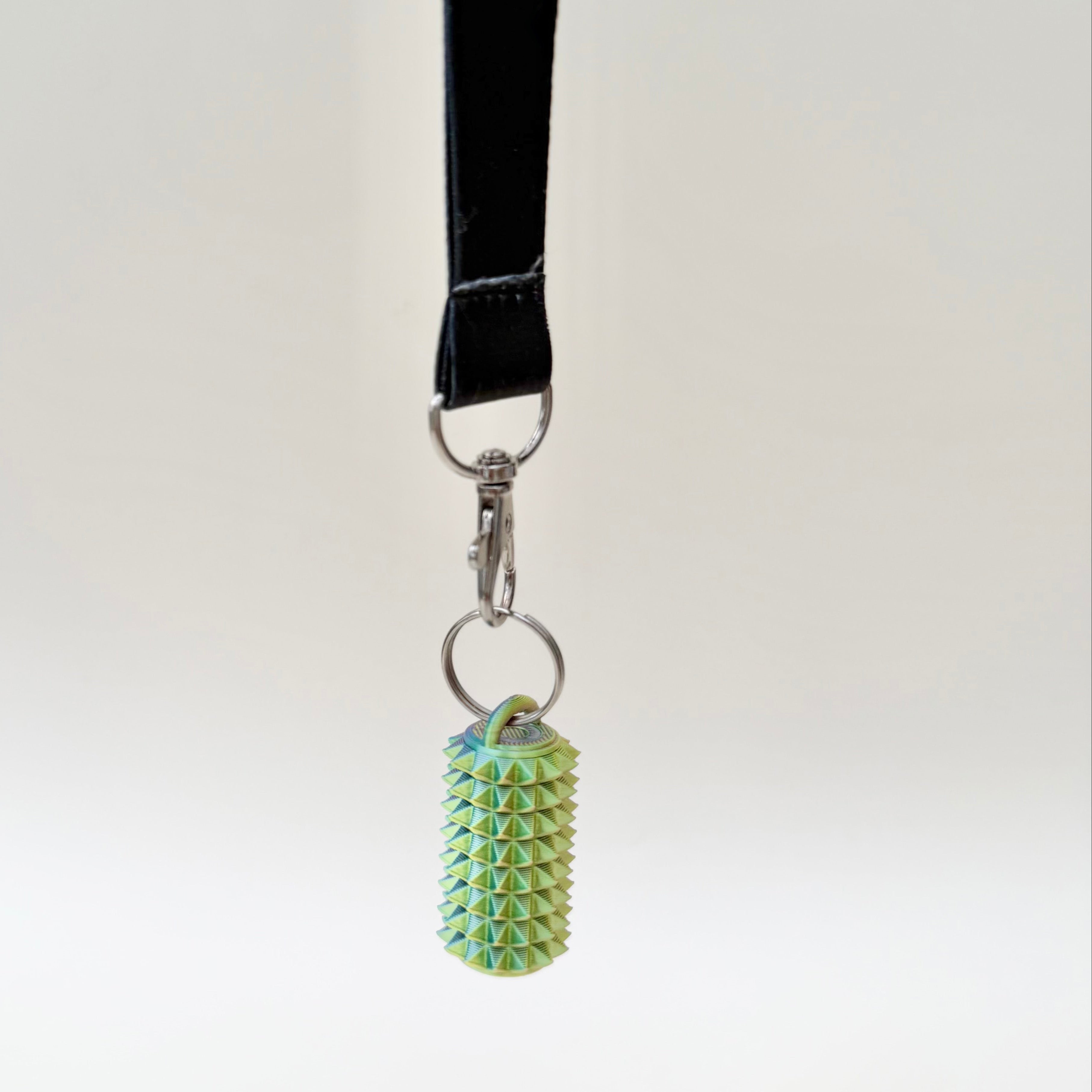 Portable spiky stim tool for tactile feedback and grounding moments, made to clip onto lanyards, bags or coats.
