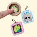 A pocket-sized shelf-style clicker fidget with a keyring loop and custom icon inside.
