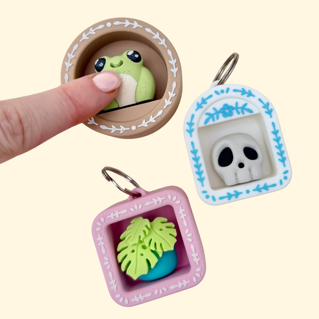 A pocket-sized shelf-style clicker fidget with a keyring loop and custom icon inside.
