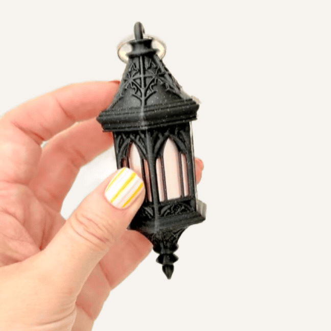 Tall lantern keychain fidget with dark sparkle finish and tactile details for everyday sensory use

