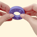 Compact press-and-flip fidget designed for repetitive popping and hand stimulation
