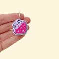 A 4cm potion bottle-shaped keyring fidget toy featuring a black bottle with shimmery green liquid and hearts inside.